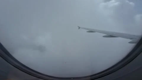 The airplane wing from the window passing through the gray clouds Stock Footage 276965027
