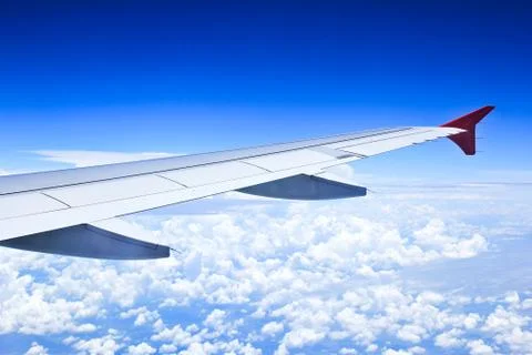 Airplane wings in the blue clouds. Stock Photos