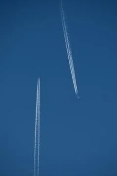 Airplanes in the blue sky with contrails. Stock Photos