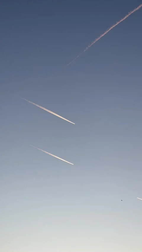 Airplanes flying on deep blue sky with chemical direction trails. Vertical Stock-Footage 292904372