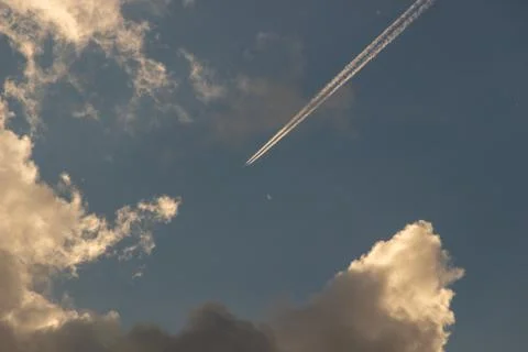 Airplanes leaves trace on clear blue sky. View from below on the trails from  Stock Photos