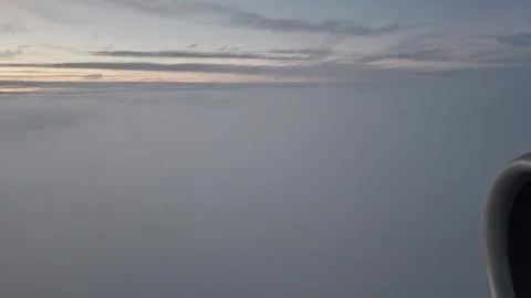 An airplane's movement as it enters a cloud layer during a sunset flight over Eu Vídeo Stock 335317689