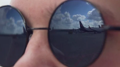 Airplanes Reflected in the Dark Sunglasses Stock Footage 130023904