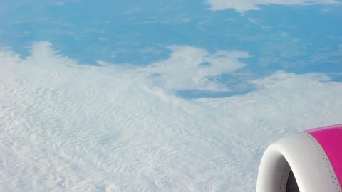 Airplane's wing and engine flying above the colorful land. Airplane window view Stock-Footage 85128272