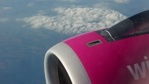 Airplane's wing and engine flying above the colorful land. Airplane window view Stock Footage 85128502
