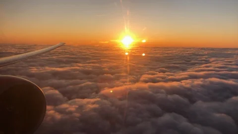 Airplane's wing and jet engine above the field of clouds on sunset, porthole Stock Footage 122769204