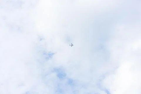 Airpline in sky with clouds low angle view from ground floor Stock Photos
