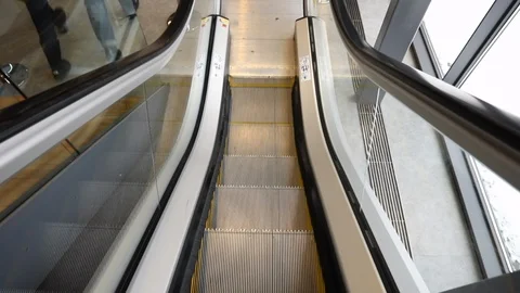Airport escalator goes down with two people next to Stock Footage 122374761