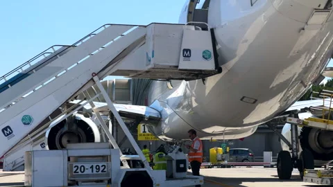 Airport ground crew working beneath aircraft wingtip Видео 328707229