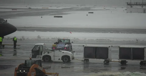 Airport Luggage Tractor Pulling Carts in a Snow Storm Stock-Footage 329410345