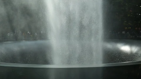 Airport passengers in Rain Vortex waterfall, Jewel Changi Airport, Singapore Видео 110453616