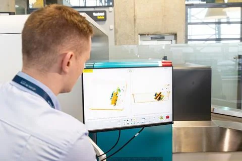 Airport security baggage screening. Security man looking at monitor scanning Stock Photos