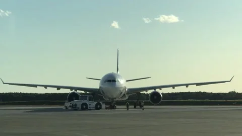 Airport towing tractor pulling an airplane on the runway Stock Footage 342646154