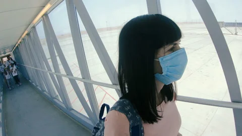 The airport. A woman in a medical mask walks through the airport lounge. Stock Footage
