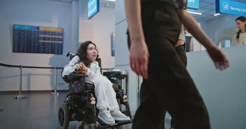 Airport Worker Walks with Passenger with Disability at Security Checkpoint for Stock Footage 307117985