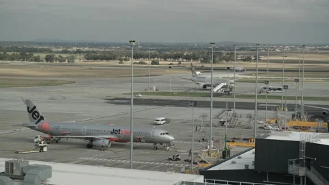 Airport Workers Begin the Process of Unloading Jetstar Jet At Melbourne Airport Stock Footage 238425730