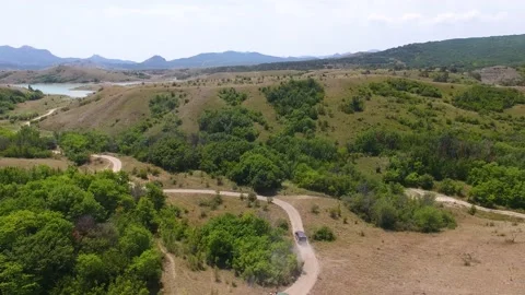 Airsoft. Aerial view. Two SUVs with soldiers are moving along the mountain road Stock Footage 131215657