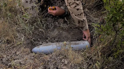 Airsoft. Close-up. Demining. A sapper works, digs a shell Stock Footage 129133796