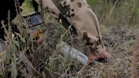 Airsoft. Close-up. A sapper works, digs a shell. He has an ID around his neck 스톡 동영상 129133800