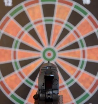 Airsoft gun aiming at target - dartboard Stock Photos