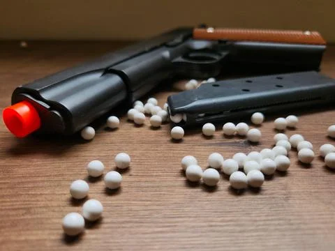 Airsoft gun and white BBs Stock Photos