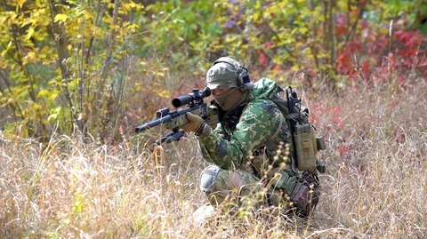 Airsoft man with optical sight gun. Soldier slink away through the grass Video stock 126551990