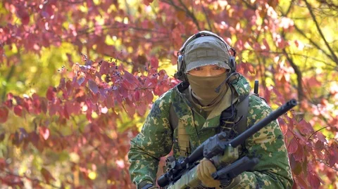Airsoft man with optical sight gun. Soldier slink away through forest territory Stock Footage 126552003