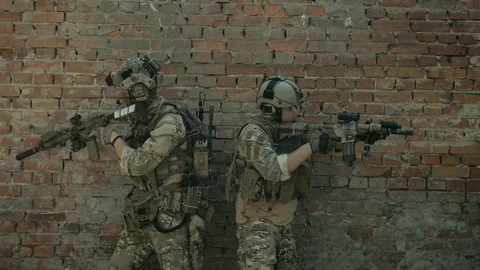 Airsoft men back to back look around the corner with gun. Urban territory. Video stock 127884150