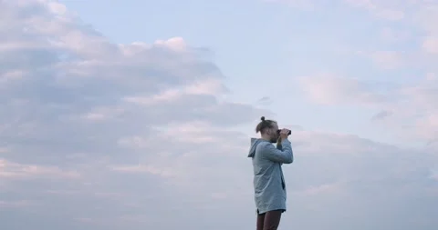 Airy low angle view of man birdwatching in binoculars on blue sky background Stock Footage 135646574