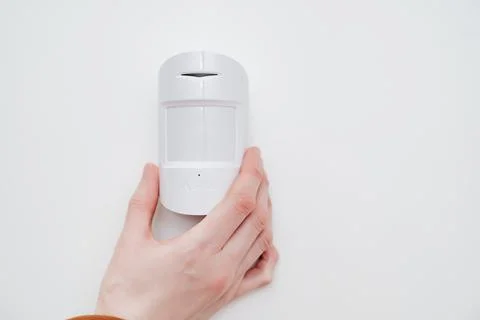 Ajax. motion sensor in hand on white. device that tracks movement of objects. Stock Photos