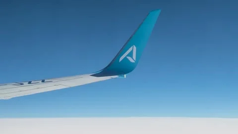 AJet airplane wing flies high in the clear blue sky over white clouds. Stock Footage 336930357