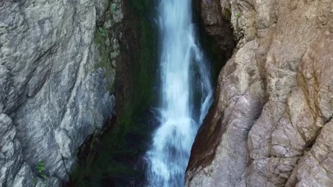 Akkum waterfall stream rushing down dark basalt gorge in Kazakhstan wilderness Stock Footage 337936768