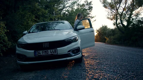 Akyaka, Turkey - CIRCA 2022: young woman in white shirt open door of white car Stock Footage 221436879
