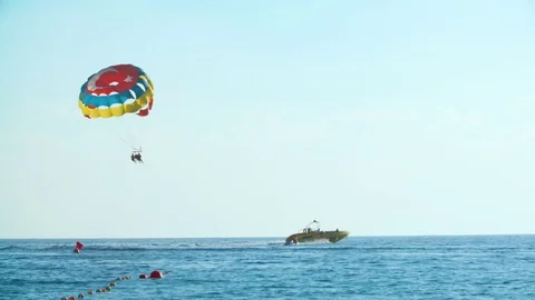 Alanya, Turkey - August 24, 2016: boat tows multi-colored parachute with Stock Footage 75344530