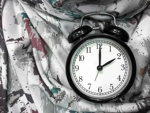 Alarm Clock at 2 O'clock with Abstract Fabric Background Stock Photos