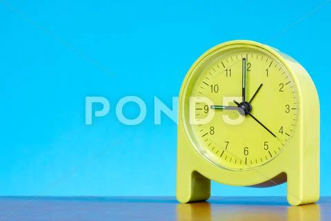 Alarm clock against blue background Stock Photos