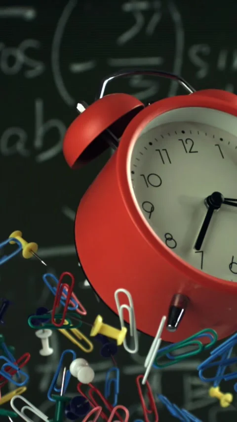 Alarm clock and school tools soaring up against the blackboard background Stock Footage 335374246