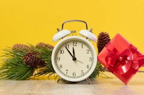 Alarm clock and stack of red gift boxes on yellow background Alarm clock a... Stock Photos
