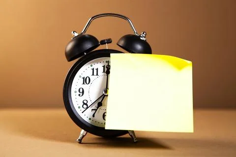 Alarm clock and sticky note on wooden table. Time management concept Stock Photos