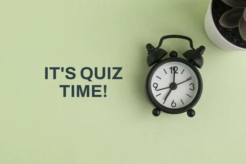 Alarm clock and text reading IT'S QUIZ TIME! on a paper background, represe.. Stockfoto's