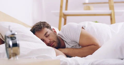 Alarm, clock and wake up, man in bed sleeping for rest or refresh in morning Stock Footage 242052197