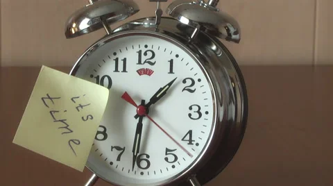 An alarm clock and a yellow note with this text: "its time " Stock Footage 47292253