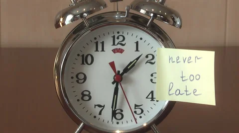 An alarm clock and a yellow note with this text: "never too late " Stock Footage 47292470