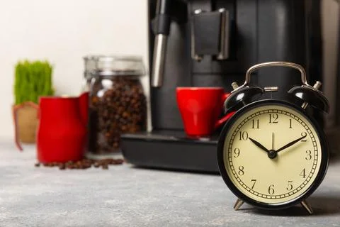 Alarm clock on the background of the coffee machine Stock Photos