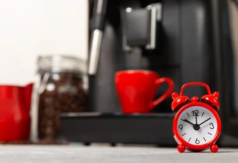 Alarm clock on the background of the coffee machine Stock Photos