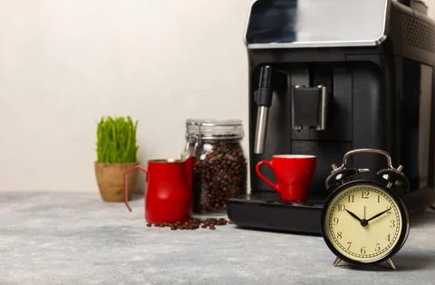 Alarm clock on the background of the coffee machine Stock Photos