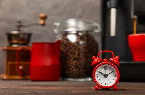 Alarm clock on the background of the coffee machine Stock Photos