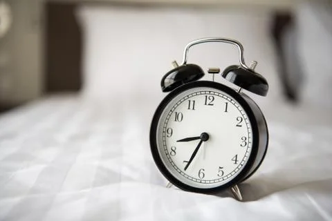 Alarm clock on bed Foto stock
