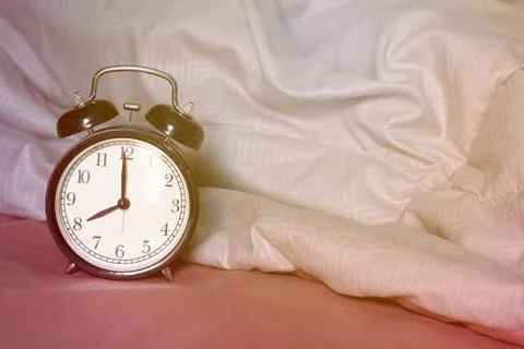 Alarm Clock on The Bed Stock Photos