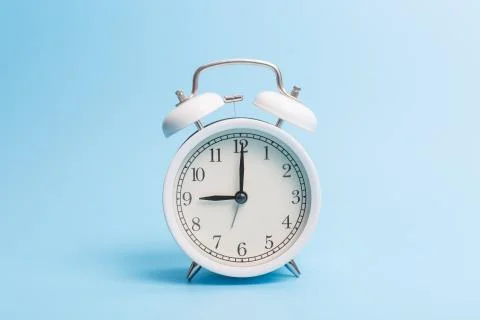 Alarm clock on blue background Stock Photos